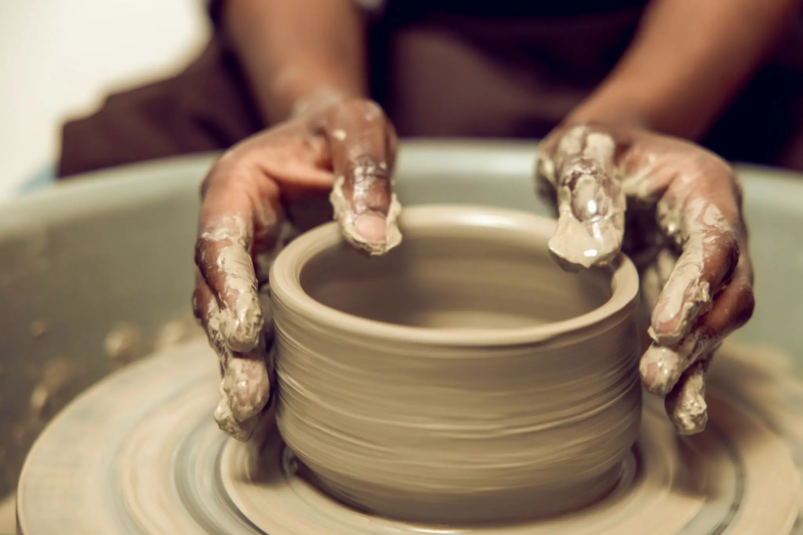 blob A person is making pottery on the potter 's wheel.
