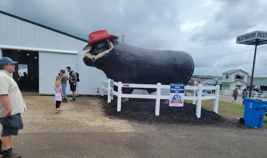 Giant cow statue wearing red cowboy hat
