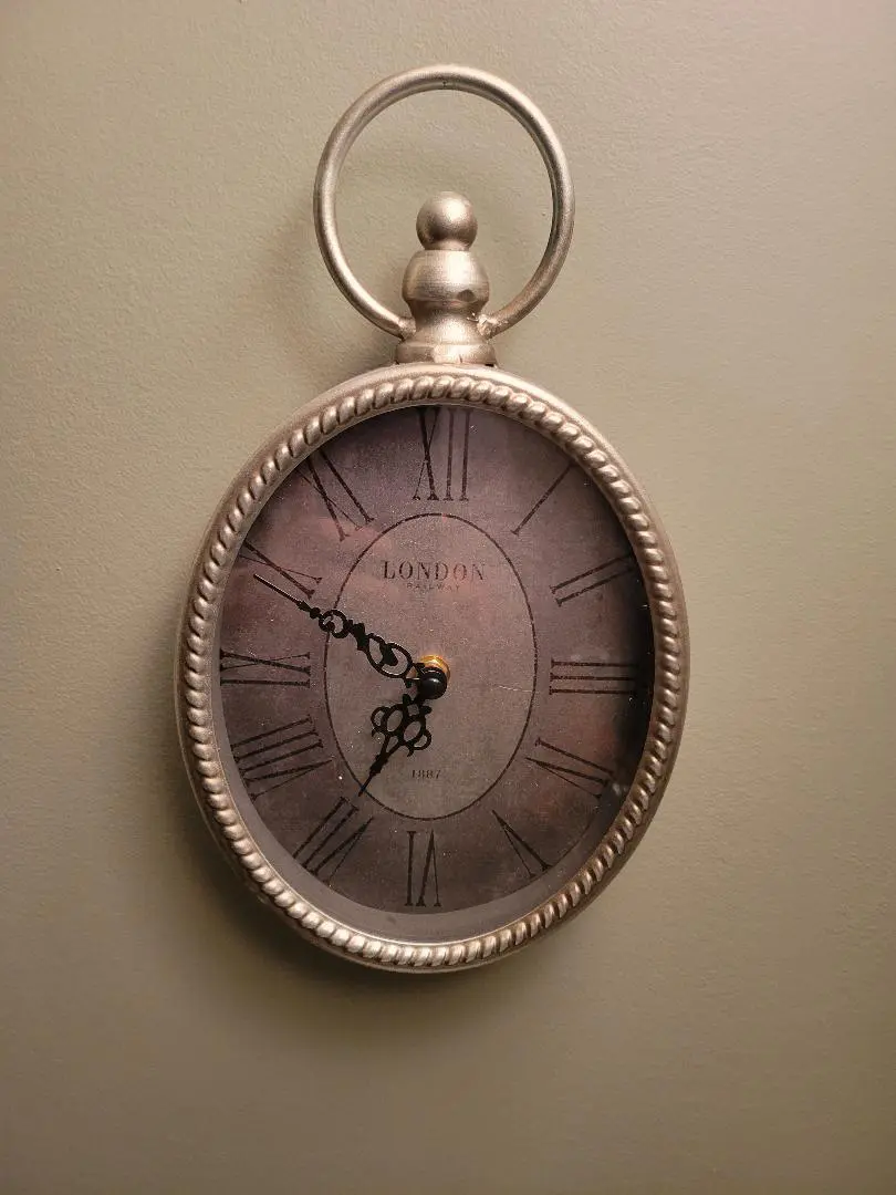 Vintage pocket watch with intricate hands and Roman numerals.