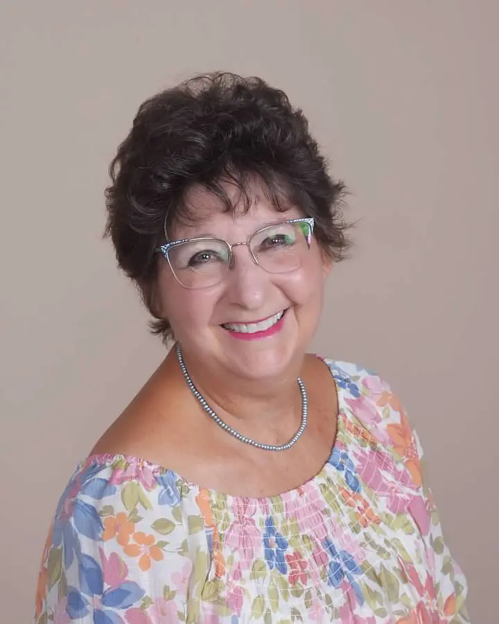 Smiling woman wearing glasses and floral blouse